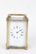 French brass carriage clock, the angular handle above a white dial with Roman numerals and retailers