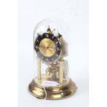 Elo brass anniversary clock, under glass dome, the circular dial with Arabic numerals, 21cm high