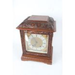 Lenzkirch walnut cased mantel clock, the foliate scroll carved pediment above an acanthus leaf and