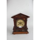 Junghans walnut cased mantel clock, the triangular pediment with turned finials above the ivorine