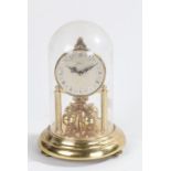 Kern Germany anniversary clock, the dial with Roman numerals above four rotating gilt orbs, housed