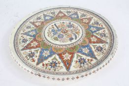 Thun pottery plate, centred with a circular field of flowers within a star shaped border,