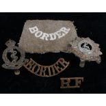 First World War cloth slip on shoulder title to the Border Regiment, together with cap badges to the