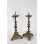 Pair of 17th century style brass pricket candlesticks, each with knopped columns raised on