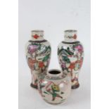 Two Japanese vases and a ginger jar, decorated with fighting figures, some on horseback, amongst