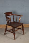 Edwardian smokers bow elbow chair, with spindle turned back and dished seat, raised on turned legs