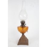 Late 19th/early 20th century oil lamp, with bulbous glass chimney and amber glass reservoir,