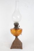 Late 19th/early 20th century oil lamp, with bulbous glass chimney and amber glass reservoir,