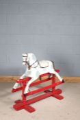 Early 20th century wooden rocking horse, later painted in white and grey on a red base, 110cm long
