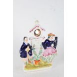 Staffordshire pottery pocket watch holder, modelled as two figures dancing and playing cymbals