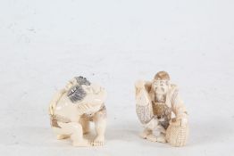 Two Japanese Meiji period carved ivory netsuke, in the form of two sumo's, with red and black