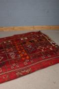 Middle Eastern carpet, the red ground with multiple lozenge pattern centre, 200cm wide
