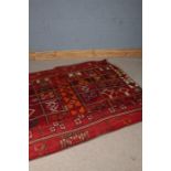 Middle Eastern carpet, the red ground with multiple lozenge pattern centre, 200cm wide