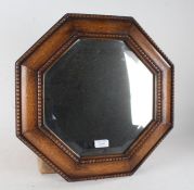 Edwardian oak wall mirror, of octagonal form with bevelled mirror plate, 43cm diameter