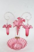 Victorian red and clear glass epergne, the wavy circular base containing two vases and two hanging