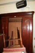 Victorian mahogany single door wardrobe, the mirrored door enclosing a hanging rail, the base fitted
