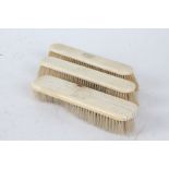 Three late 19th/early 20th century ivory mounted brushes, each monogrammed, 18cm long (3)