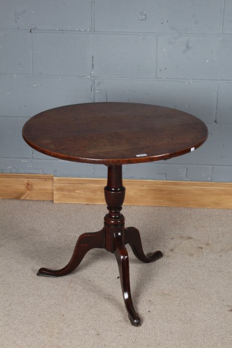 George III style oak tilt-top table, the circular top raised on a turned stem with tripod legs and