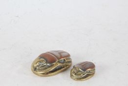 Two Egyptian revival brass Scarab Beetles, each with white metal inlay and hieroglyphics (2)