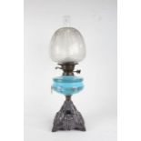 Late Victorian glass and cast iron oil lamp, having etched glass shade above a blue pressed glass