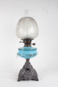 Late Victorian glass and cast iron oil lamp, having etched glass shade above a blue pressed glass