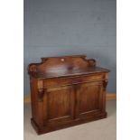 Victorian mahogany chiffonier, the scroll carved upstand above two panelled cupboard doors opening