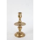 Dutch Heemskerk style brass candlestick, the shaped sconce above central drip tray, on a domed foot,