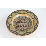 Middle Eastern earthenware dish, the central field with Islamic script and scroll decorated