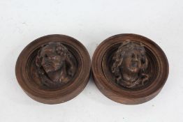 Pair of 19th century carved roundels, depicting a male and female head, 17.5cm diameter (2)