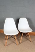 Pair of Eames style chairs, having white plastic seats and raised on spindle beech legs, 77cm