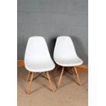 Pair of Eames style chairs, having white plastic seats and raised on spindle beech legs, 77cm