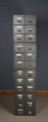 Four stackable banks of metal drawers, each bank fitted with six drawers, 194.5cm high when