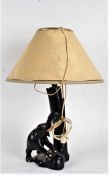 20th Century ebonised reading lamp, formed as an elephant besides a tree trunk, 49cm high