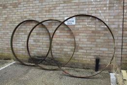 Three large cast iron wheel trims, approx. 141cm diameter and 159cm diameter (3)