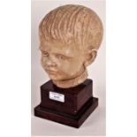 Art Deco style pottery bust, in the form of a boy, raised on a marble effect plinth, 23.5cm high