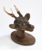 Folk art carved deer's head, the carved head with two carved antlers mounted on an oval shield,