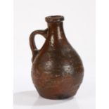 17th Century brown glazed bottle, with a wide lip above a bulbous body and arched handle, 19cm