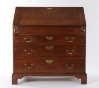 George III oak bureau, circa 1760, the rectangular top above a sloping fall enclosing a central