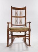 19th Century elm and ash rocking chair, with a spindle back above turned arms and a rush seat upon