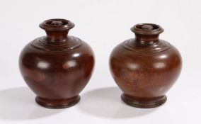 Pair of turned treen tea caddies, each with a bulbous body and a lid inside the recess of the vase