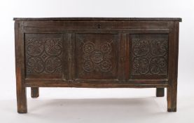 17th Century oak coffer, the rectangular top above three leaf and roundel carved panels raised on