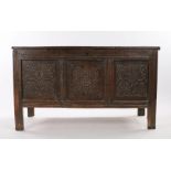 17th Century oak coffer, the rectangular top above three leaf and roundel carved panels raised on