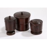 Three 19th Century hardwood treen storage jars, the first of tapering barrel form with an inset lid,