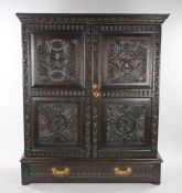 17th Century and later oak cupboard, the pediment top above two rose and thumb moulded carved