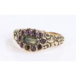 Victorian mourning ring, the head set with violet stones and a central cabochon cut stone having a