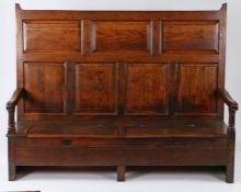 Early 18th Century oak Welsh settle, with fielded panels to the back and downswept scroll ended open