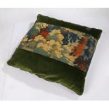 A large cushion of 17th century verdure tapestry and velvet, of foliate design in typical palette of