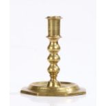 Spanish late 17th Century brass candlestick, the turned stem above a wide octagon foot, 13cm high