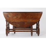 17th Century oak gateleg table, the oval drop leaf top above a single frieze drawer, raised on