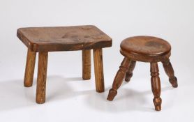 Two 19th Century elm and oak topped milking stools, the circular elm example raised on four turned